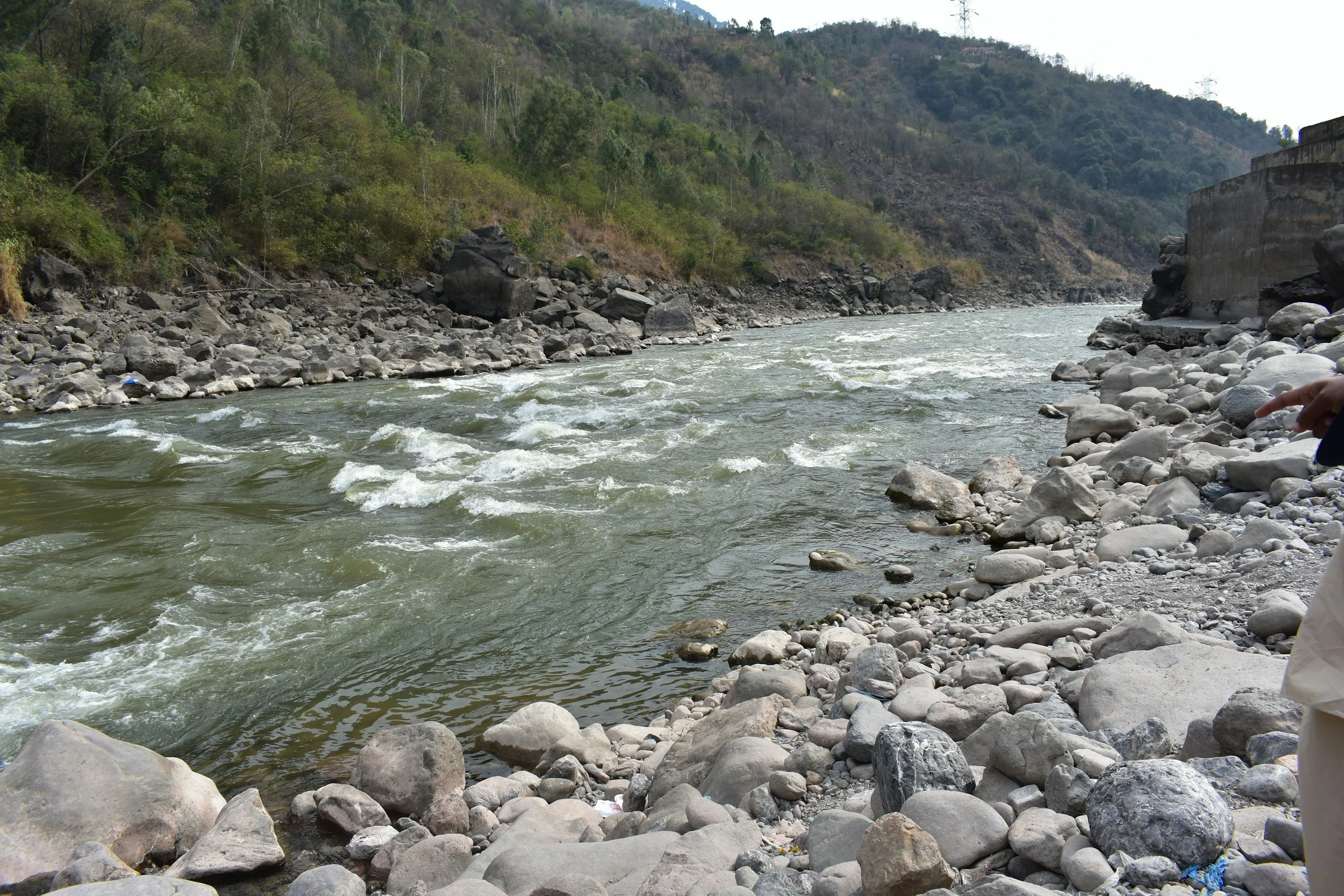 A mountain river with rocks lining the riverbank.