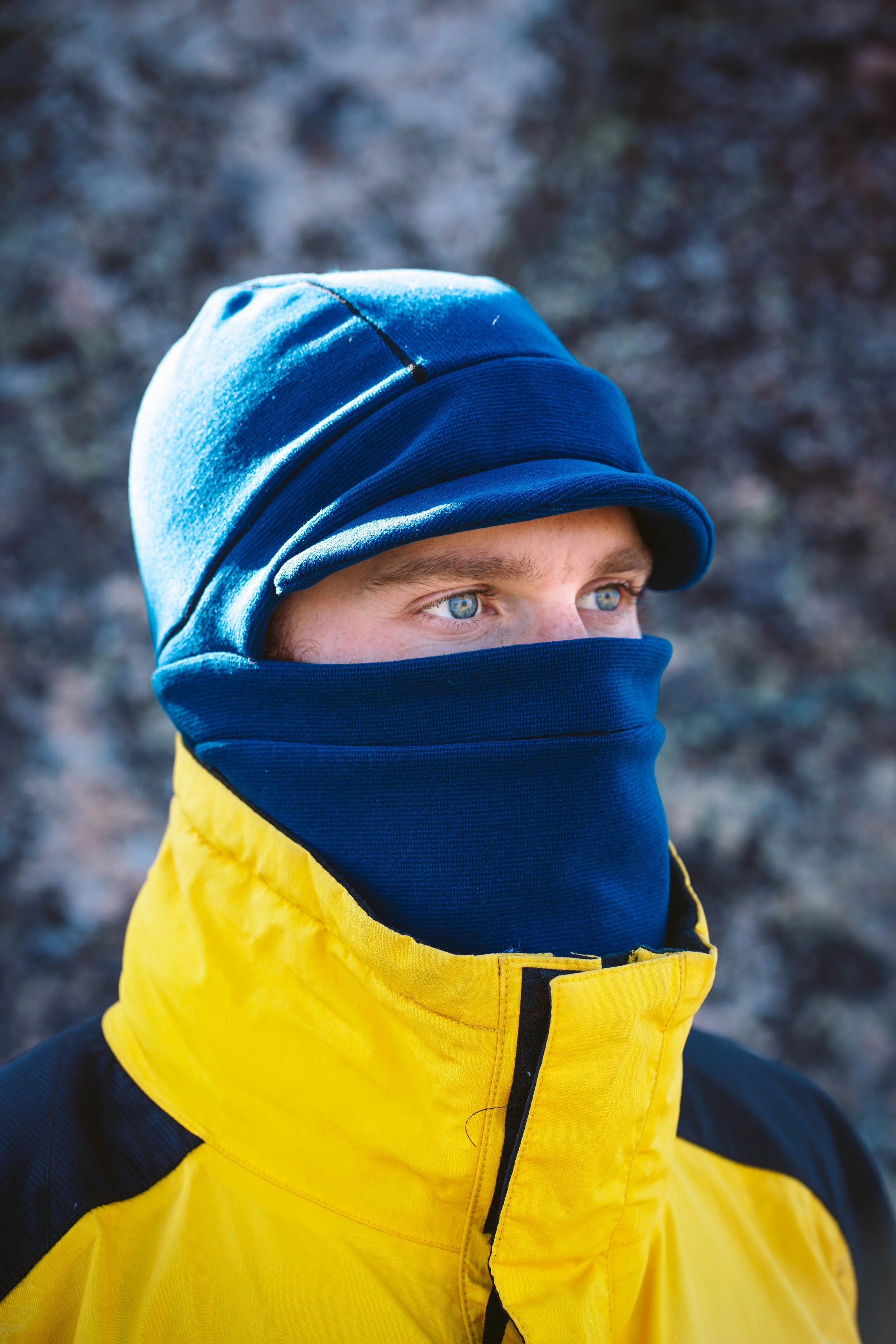 A man wearing blue balaclava with blue trim. The balaclava has a hat with a brim.