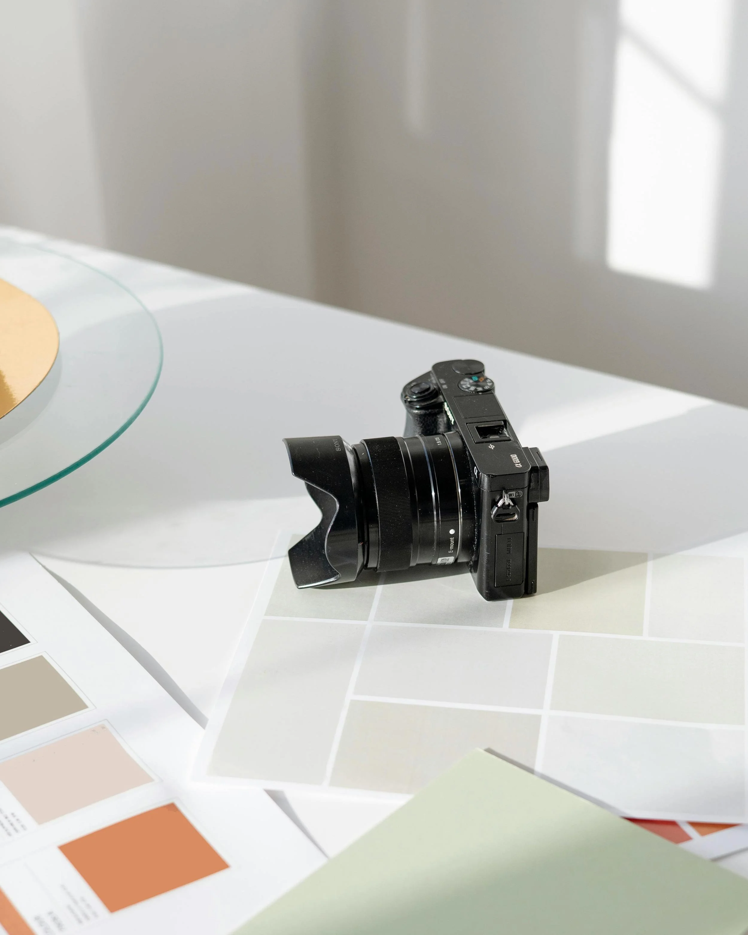 Camera and colour swatches on a table used for branding and graphic design.