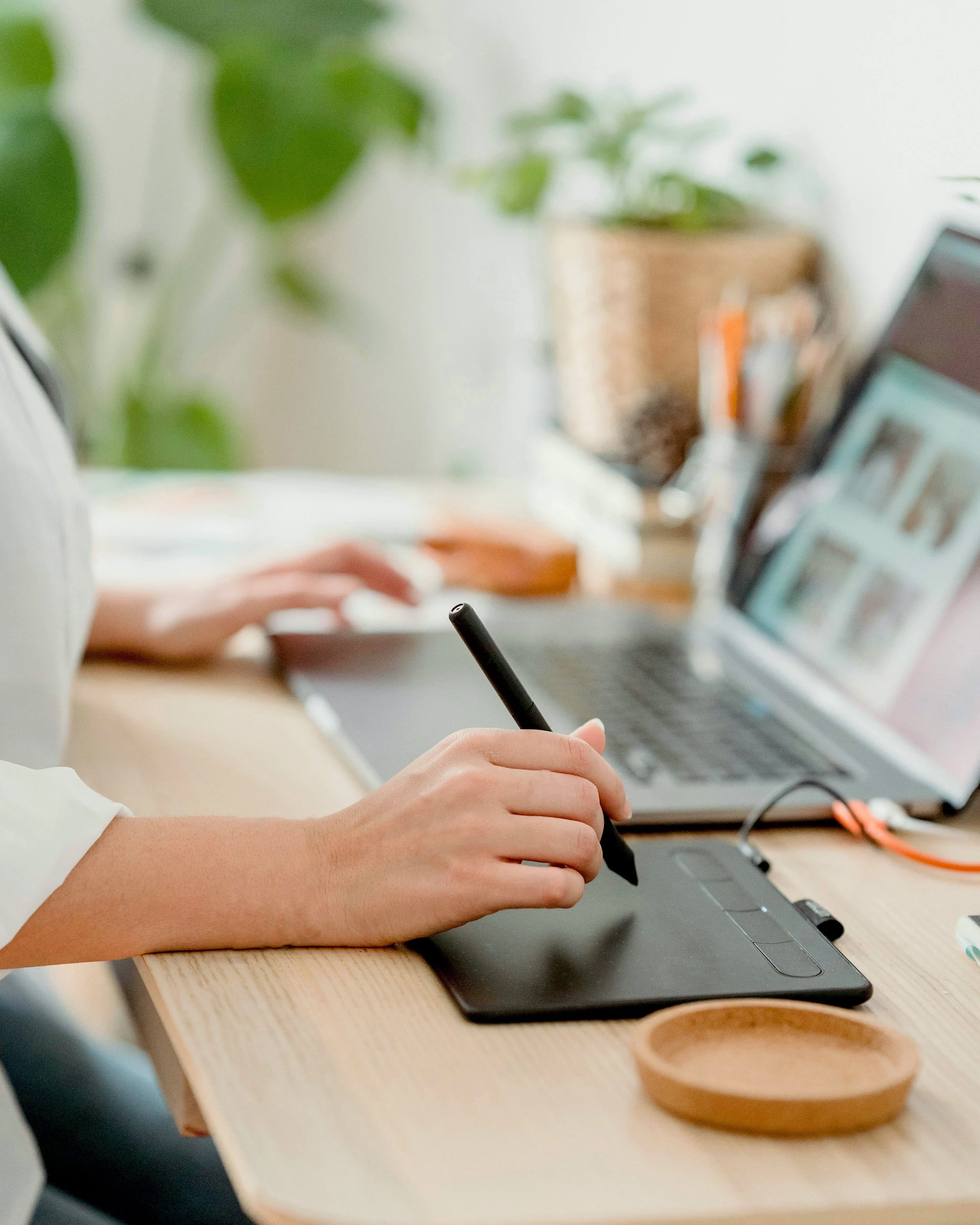 Hands editing video on a computer for digital design projects.
