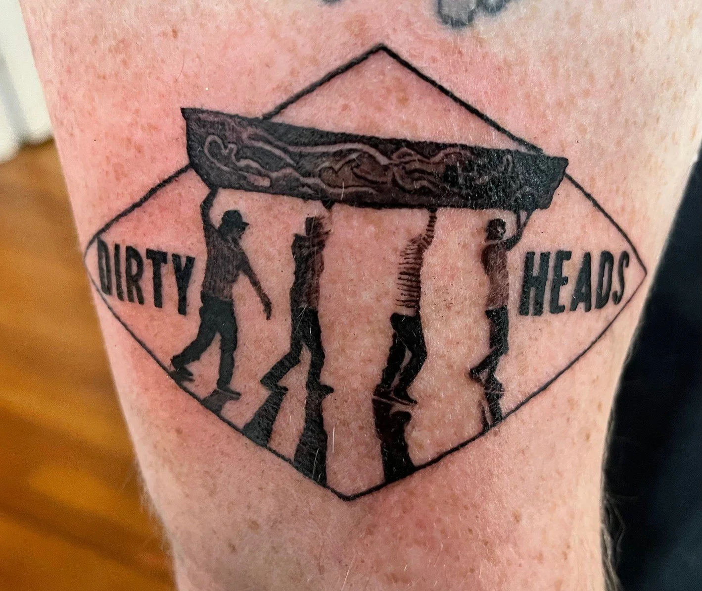 Tattoo of the Abbey Road album cover with silhouettes of four men walking across a zebra crossing, with the words 'Dirty Heads' on either side.