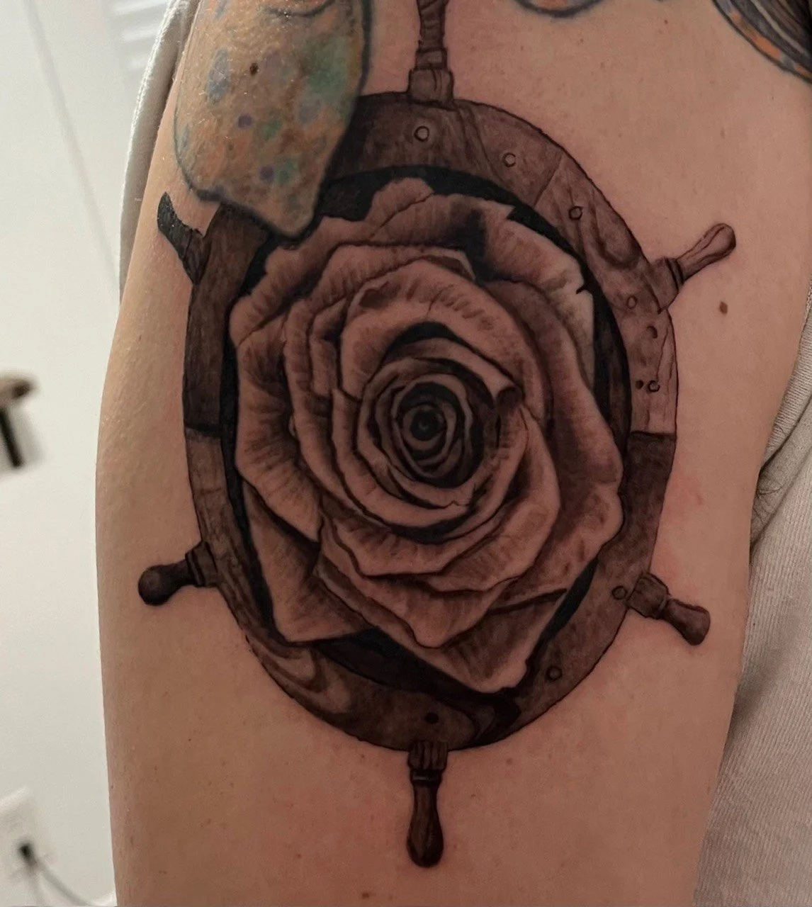 Tattoo of a stylized rose at the center of a pocket watch, with the watch's hands replaced by the flower's petals.