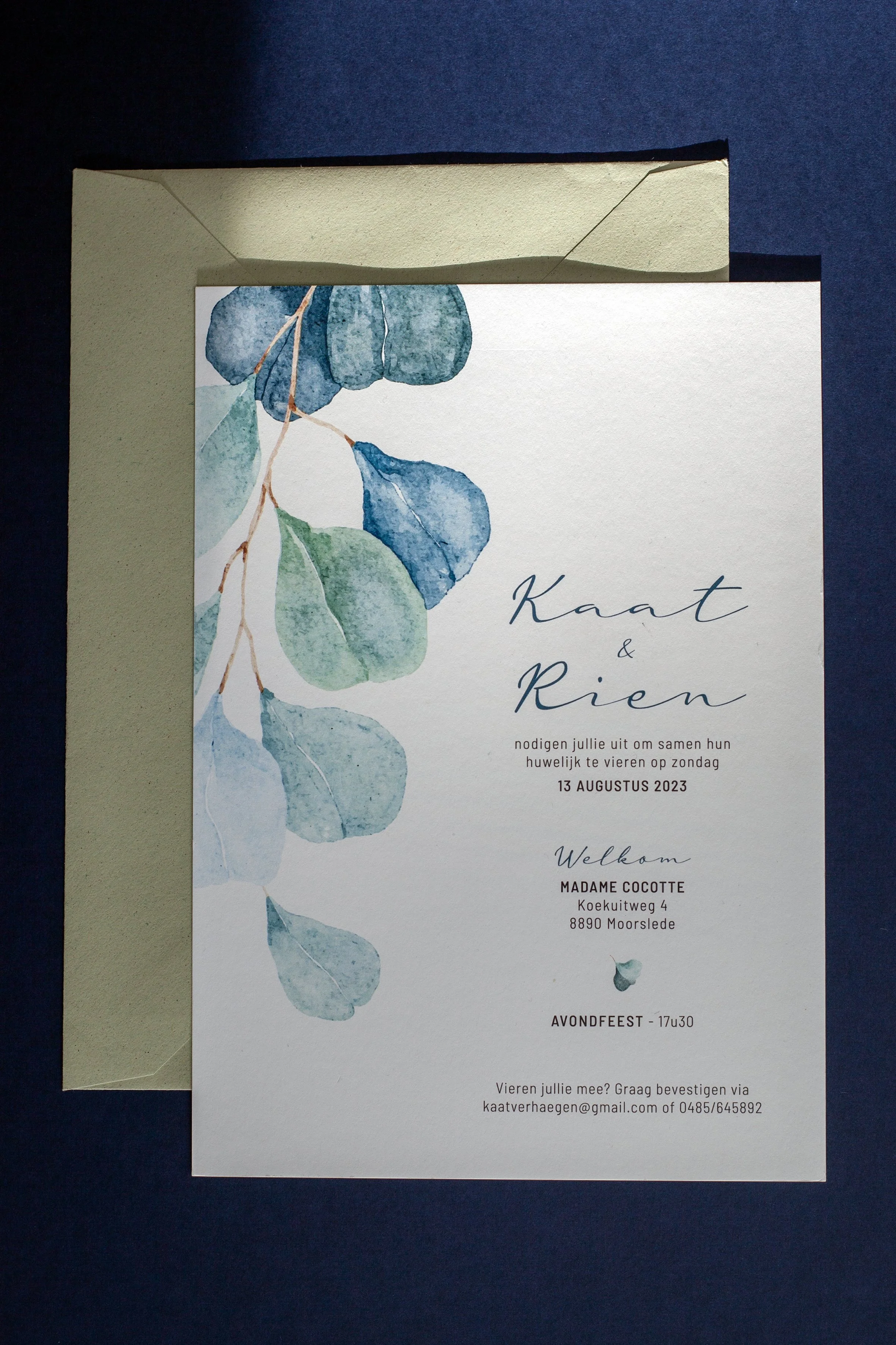 Huwelijksuitnodiging met blauwe en groene waterverf bladeren.