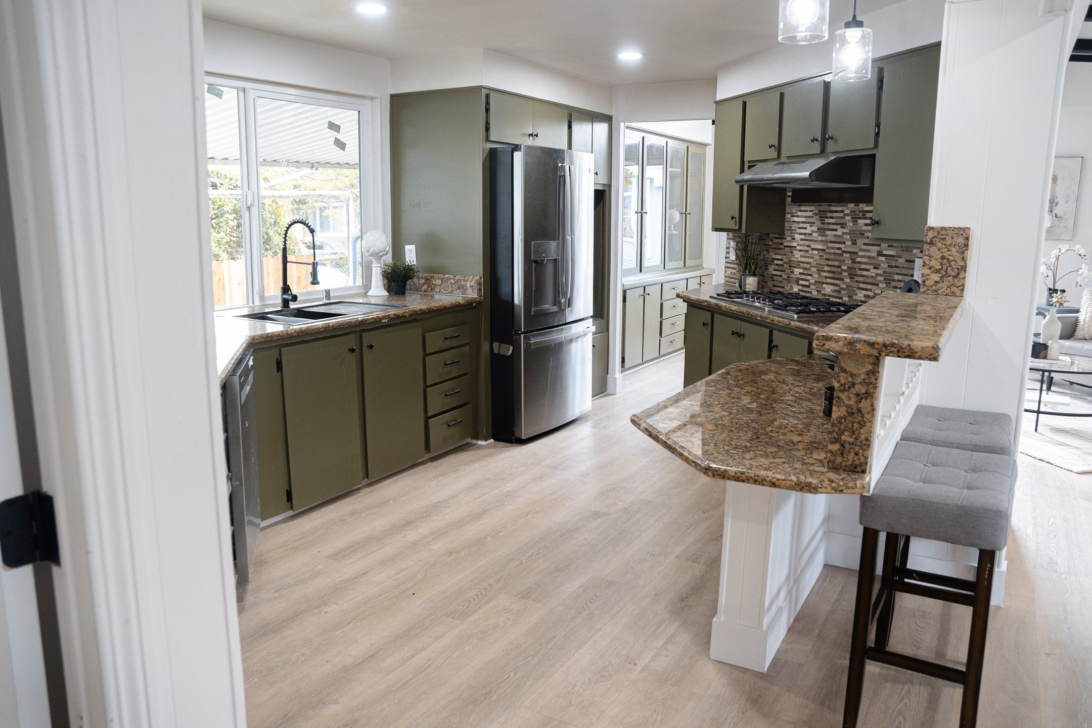 A white marble-tiled bathroom with a small window and a glass shower door.