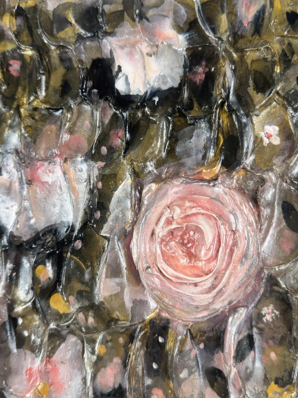 Close-up of textured, abstract artwork with pink, black, and white colors, resembling a rose and surrounding floral or organic shapes.