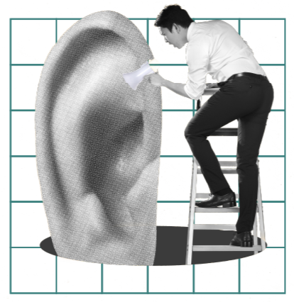 A person standing on a step stool cleaning a large, textured, ear-shaped sculpture with a cloth.