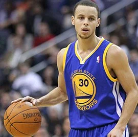 A basketball player wearing a Golden State Warriors jersey with the number 30, holding a basketball on the court.