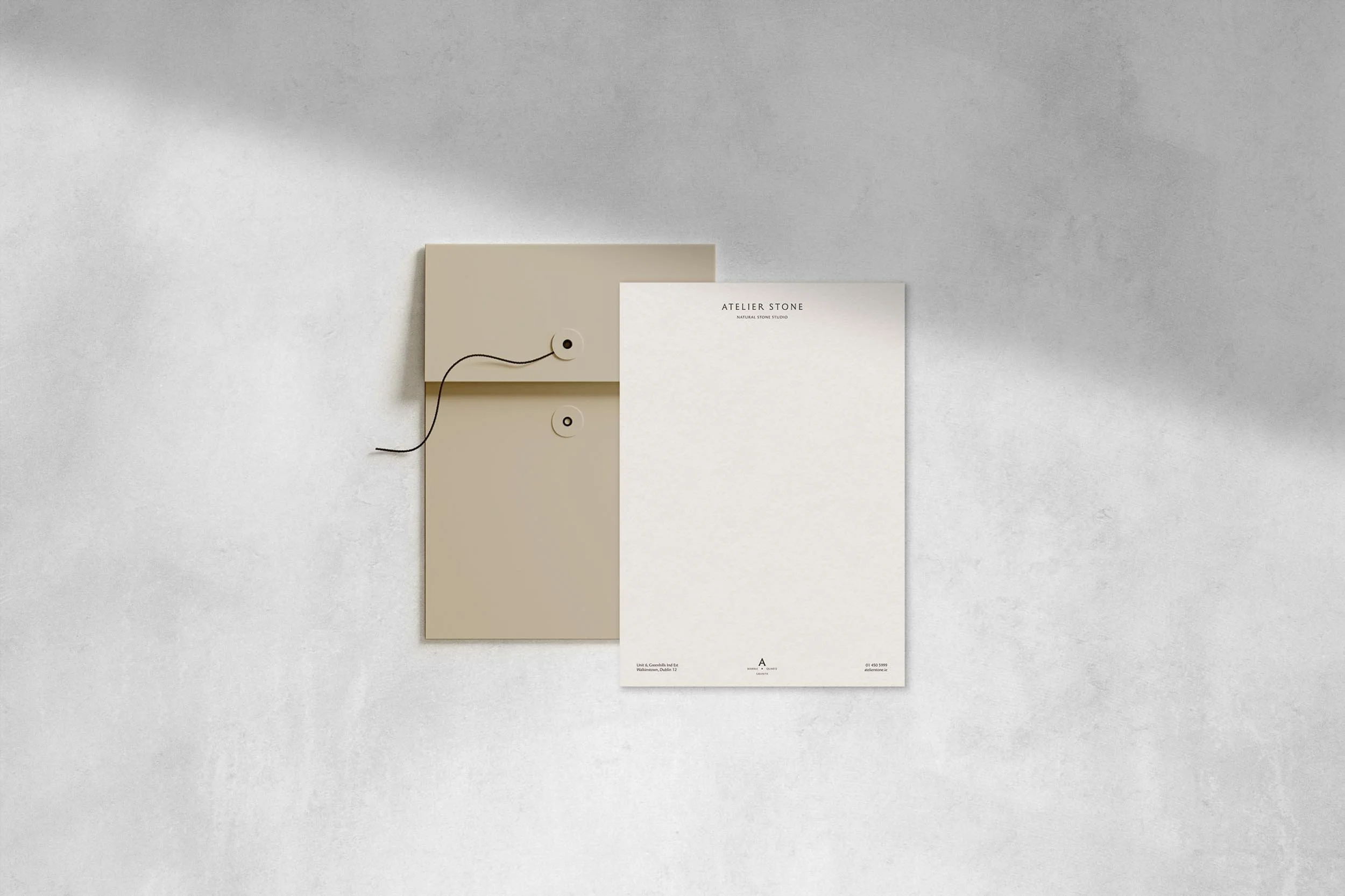 Minimalist stationery for Atelier Stone natural stone studio featuring a tan string tie envelope and clean white letterhead