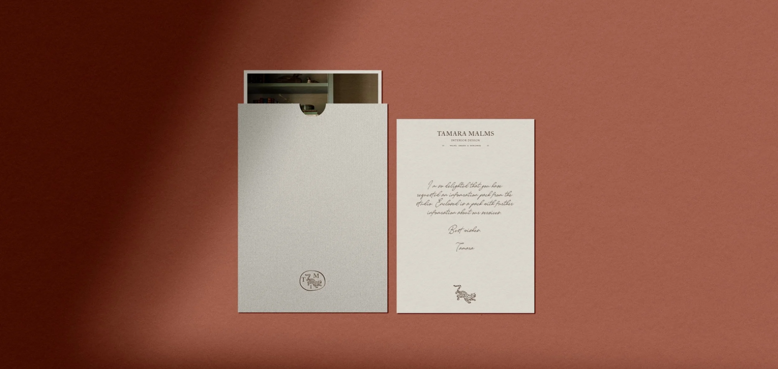 A light grey textured card sleeve next to a handwritten note featuring a small leopard logo on terracotta background