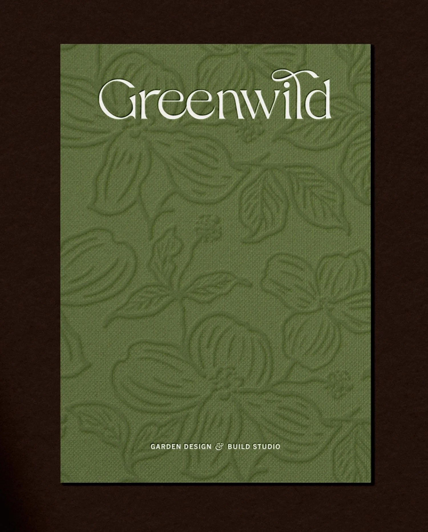 Close up of a luxury forest green folder featuring a tactile debossed floral pattern and white Greenwild studio logo