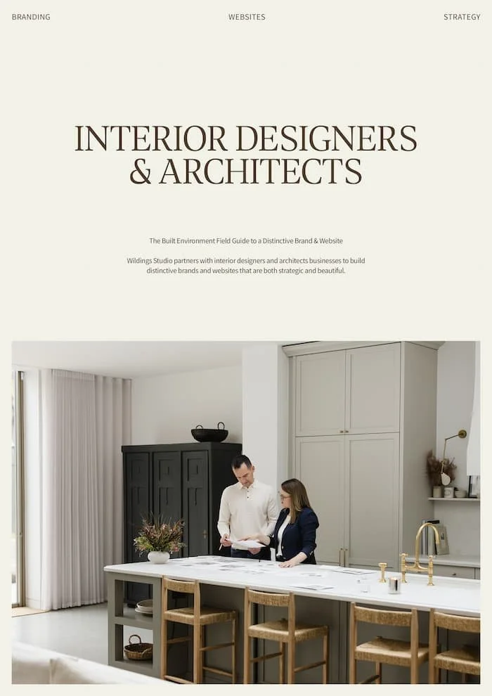 Interior designer and architect reviewing plans on a white kitchen island in a modern minimalist home with neutral tones