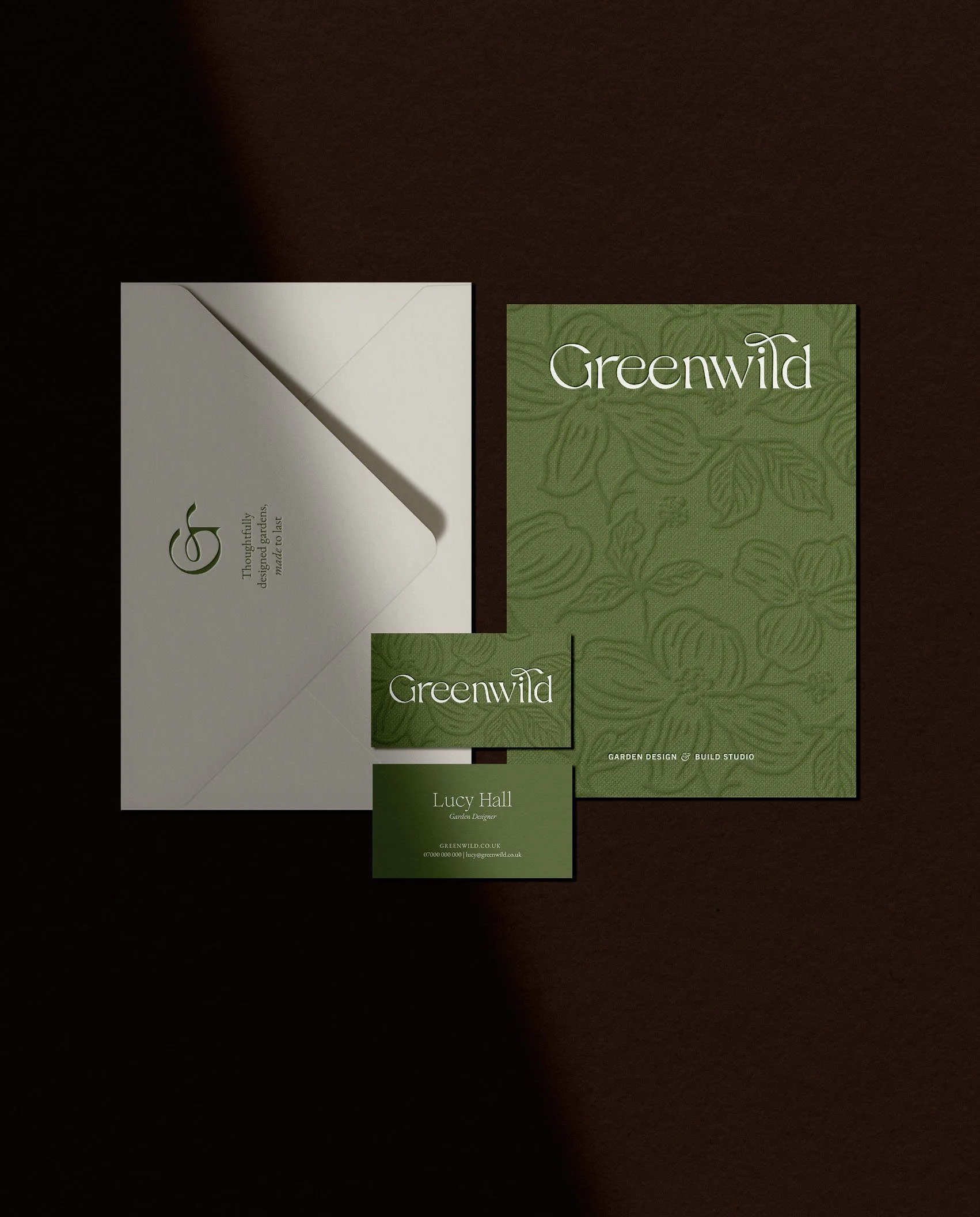 Greenwild brand stationery set with floral embossed green folder and Lucy Hall garden designer business cards on envelopes
