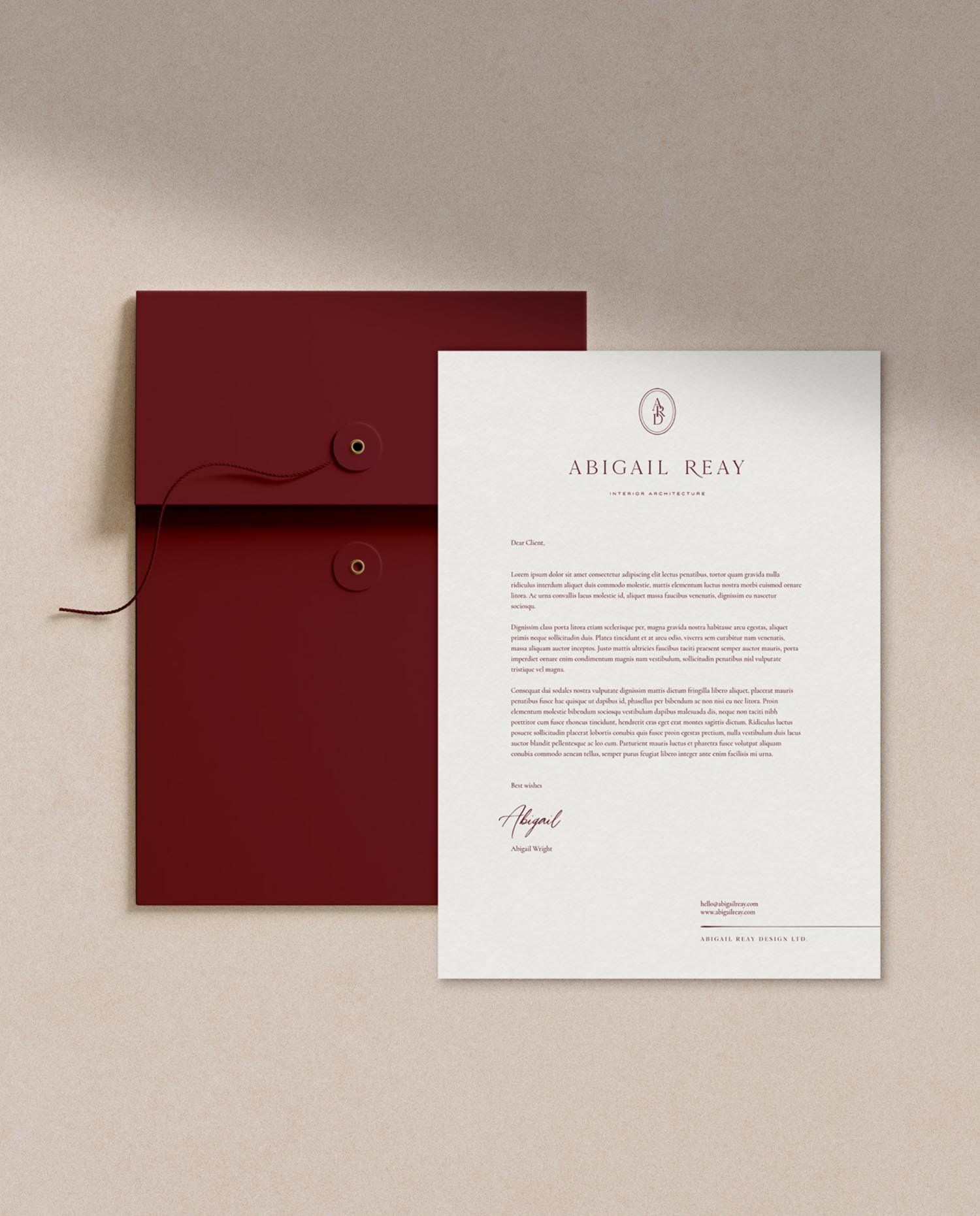 Abigail Reay branded letterhead with a signature from Abigail Wright placed next to a luxury burgundy string tie envelope