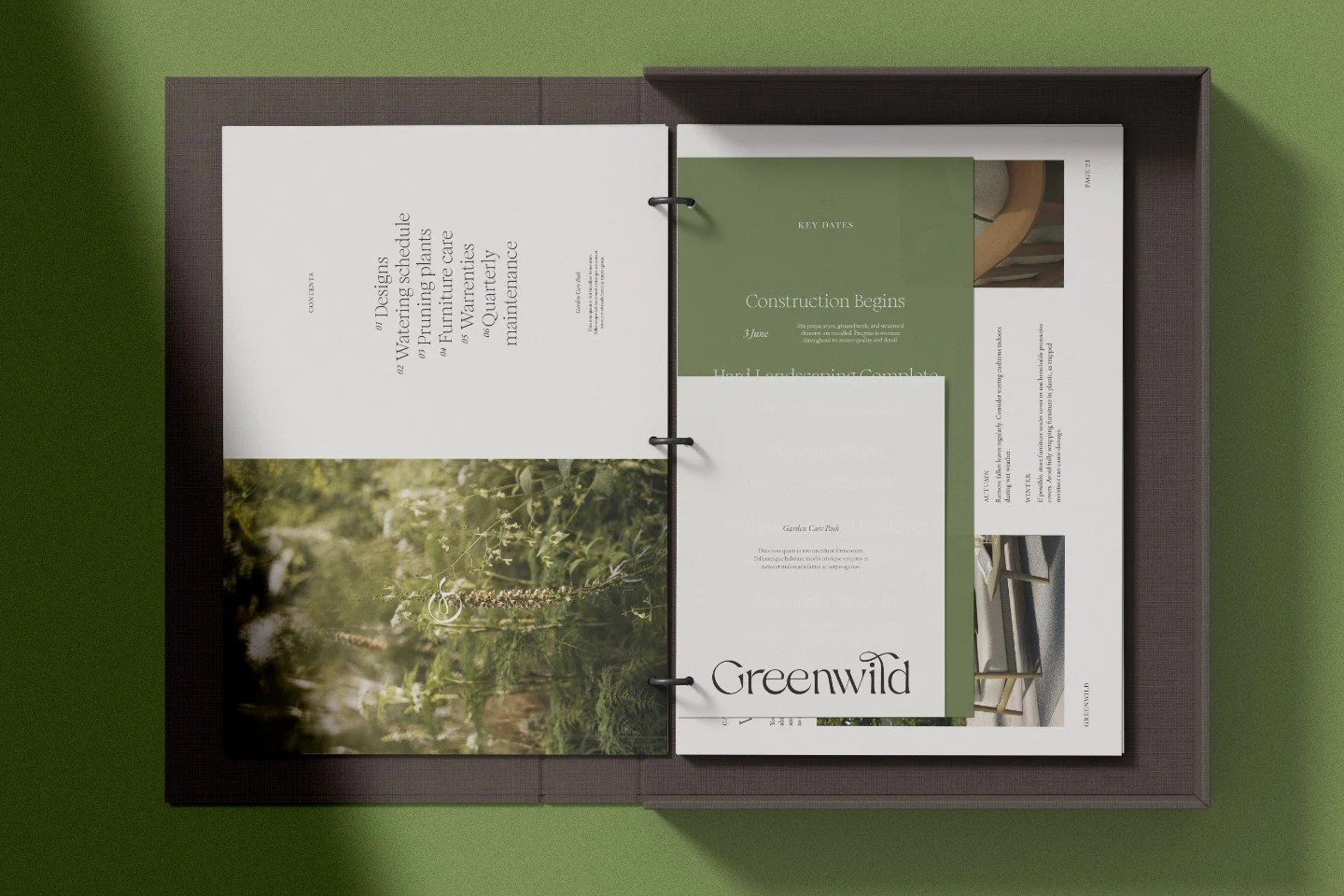 Open ring binder in a dark box showing garden design plans with the Greenwild logo and lush green plant photography