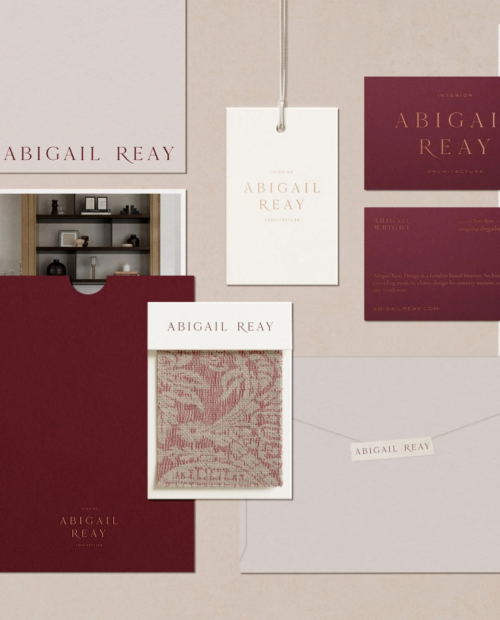 Elegant branding for an interior architect featuring burgundy business cards textured fabric samples and minimalist logo