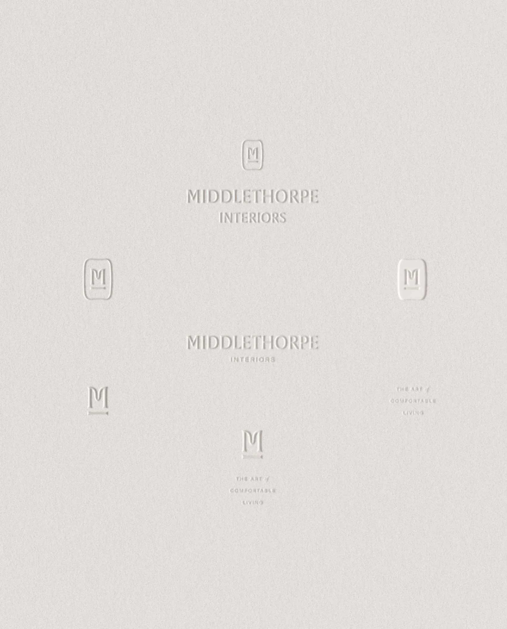 Multiple embossed variations of the Middlethorpe Interiors logo and "The Art of Comfortable Living" slogan on cream paper