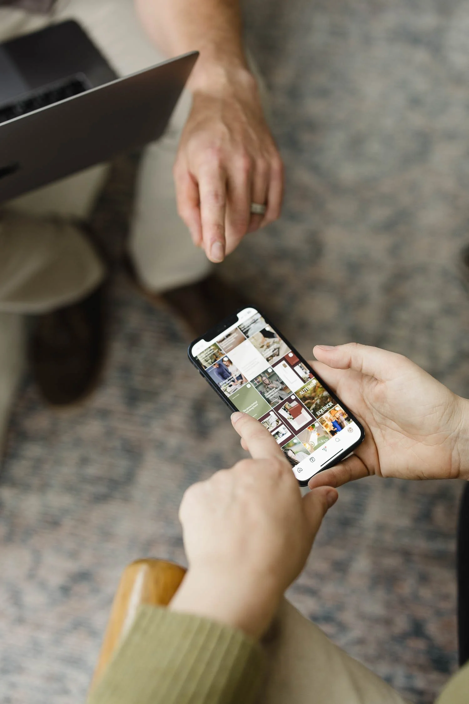 Close-up of hands scrolling through a website design portfolio on a smartphone during a creative brand consultation session