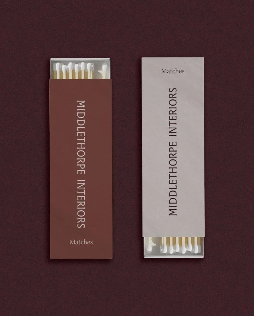 Two long match boxes in burgundy and grey with Middlethorpe Interiors branding and white-tipped matches partially visible