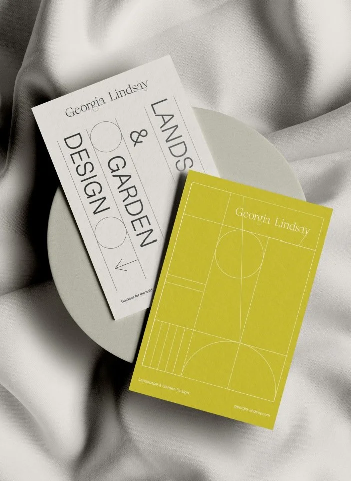 Georgia Lindsay brand stationery with white and yellow business cards featuring geometric line art on folded silk fabric