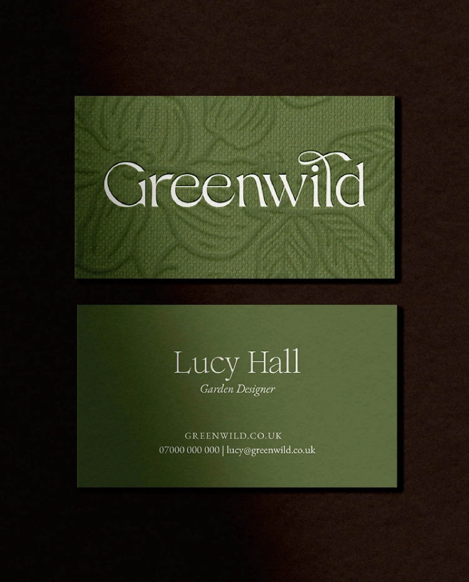 Front and back of textured green business cards for Greenwild Garden Designer Lucy Hall featuring a white serif logo