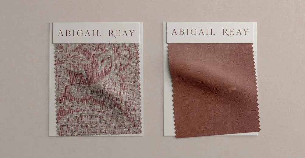 Abigail Reay branded fabric swatch featuring a traditional red and cream patterned textile for high-end interior upholstery
