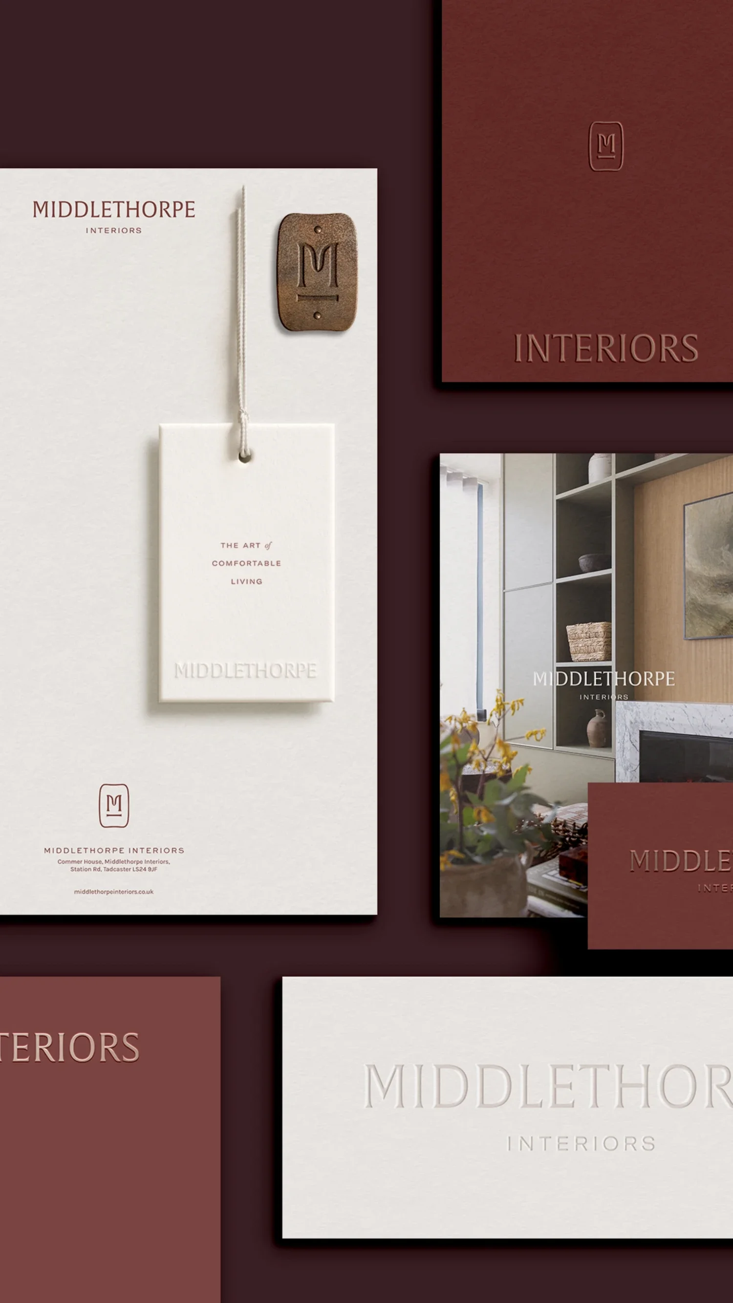 Flat lay of luxury brand stationery including swing tags foil-blocked business cards and a leather monogram mark tool