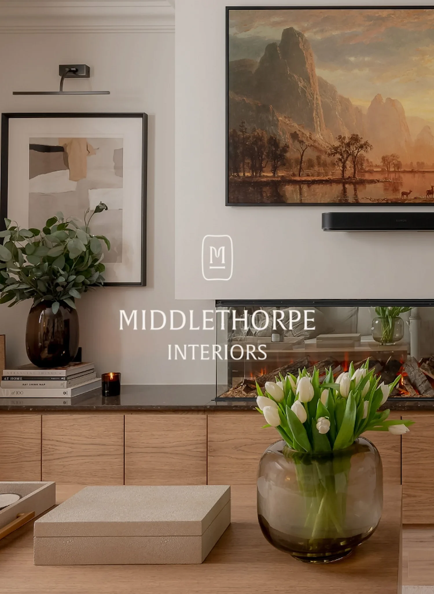 Modern living room interior designed by Middlethorpe Interiors featuring a fireplace, white tulips and landscape painting