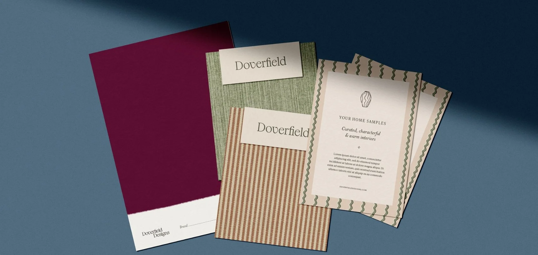 Branding kit with deep red paint swatch green fabric sample striped card and a welcome note for home interior services