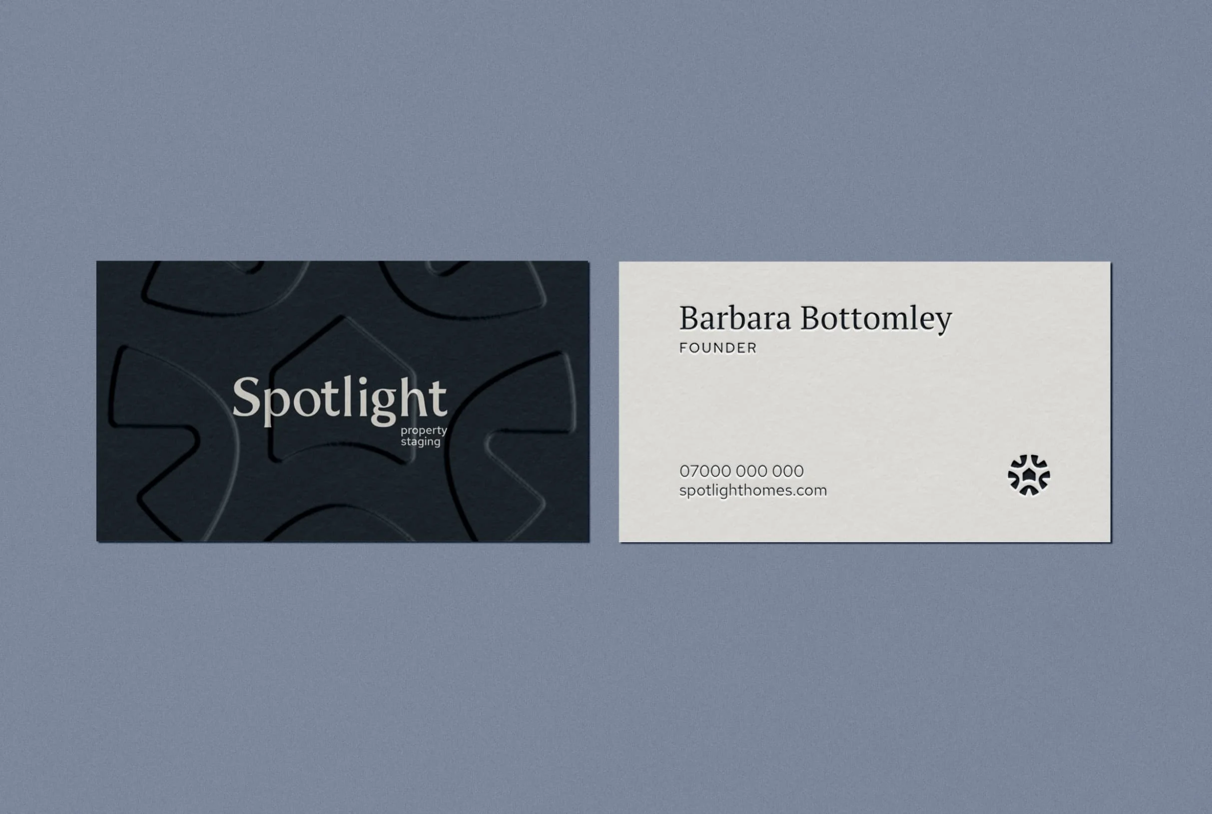 Business cards for Barbara Bottomley Founder of Spotlight on a blue surface showing contact details and embossed logo design