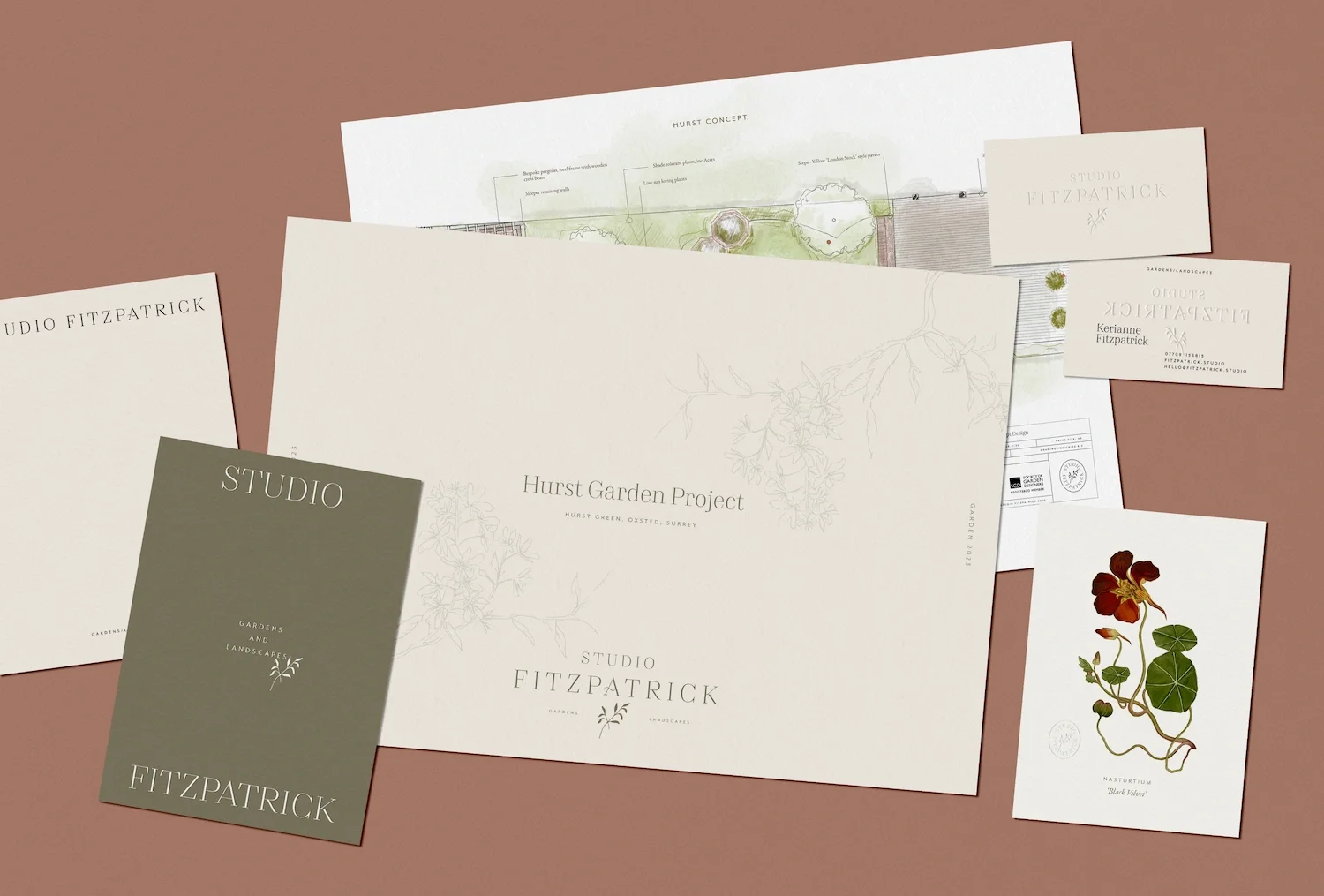 Comprehensive corporate identity kit displaying branded presentation folders envelopes cards and garden design concept plans