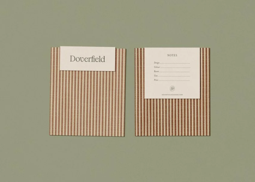 Front and back of a striped brown fabric sample card featuring the brand logo and a section for design and price notes