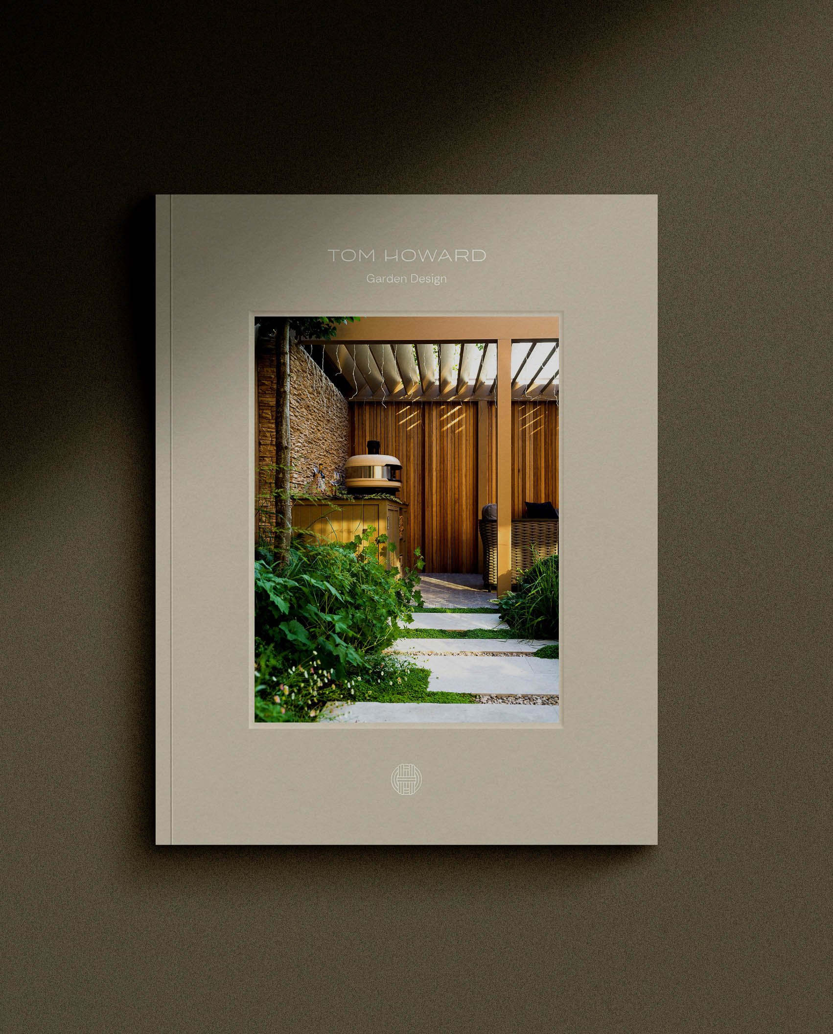 A high quality portfolio book for Tom Howard Garden Design featuring a central photo of an outdoor kitchen under a pergola
