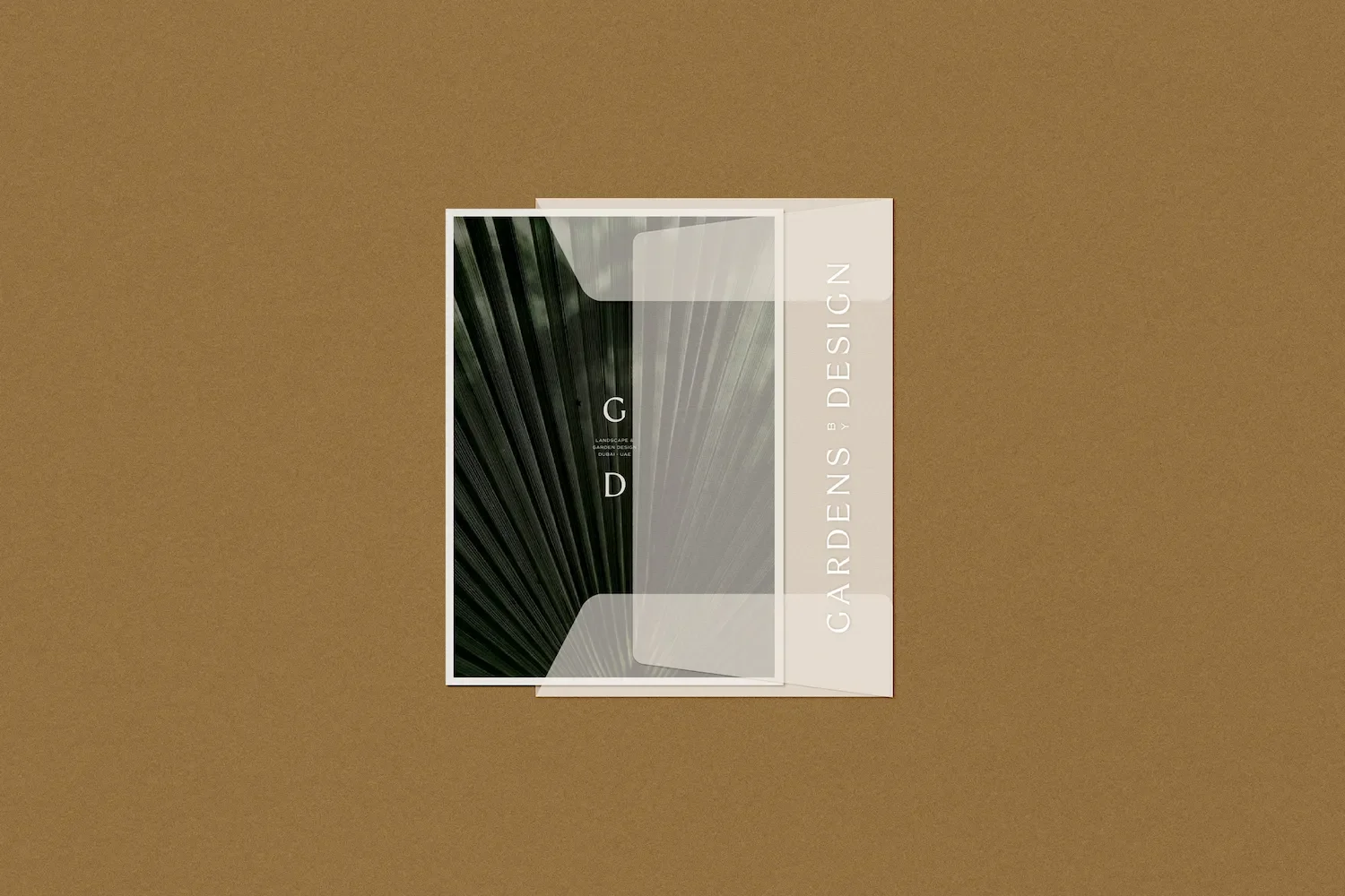 Gardens by Design translucent vellum envelope overlaying an image of palm fronds with minimalist typography and branding