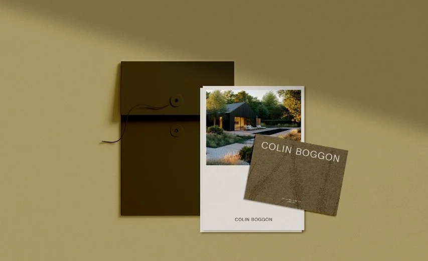 Branding mockup with a dark envelope and a postcard displaying a contemporary garden lodge next to a reflective swimming pool