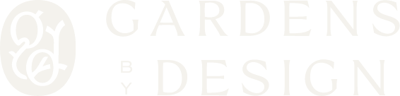 Primary logo for Gardens by Design featuring an oval monogram and elegant typography on a dark background