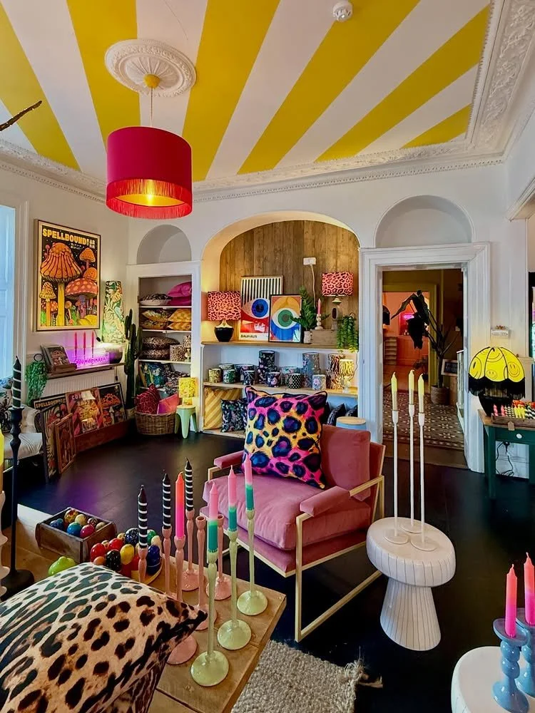 Vibrant interior of Love Frankie boutique with yellow striped ceiling bright pink lampshades and eclectic leopard print