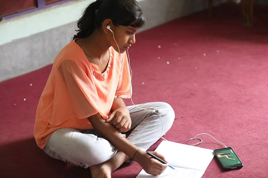 A young woman works on homework in a notebook