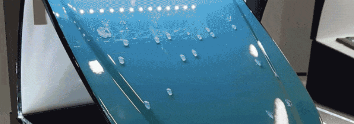 Close-up of a blue smartphone with water drops on its screen, sitting on a stand.