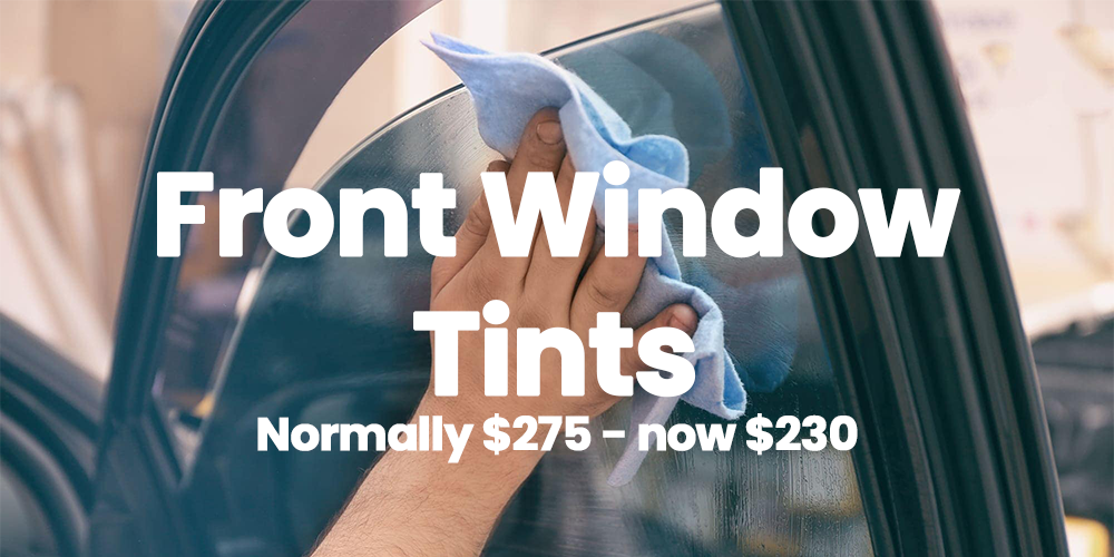 Close-up of a person cleaning a car's front window with a blue cloth. Overlaid text reads 'Front Window Tints, Normally $275 - now $230.'