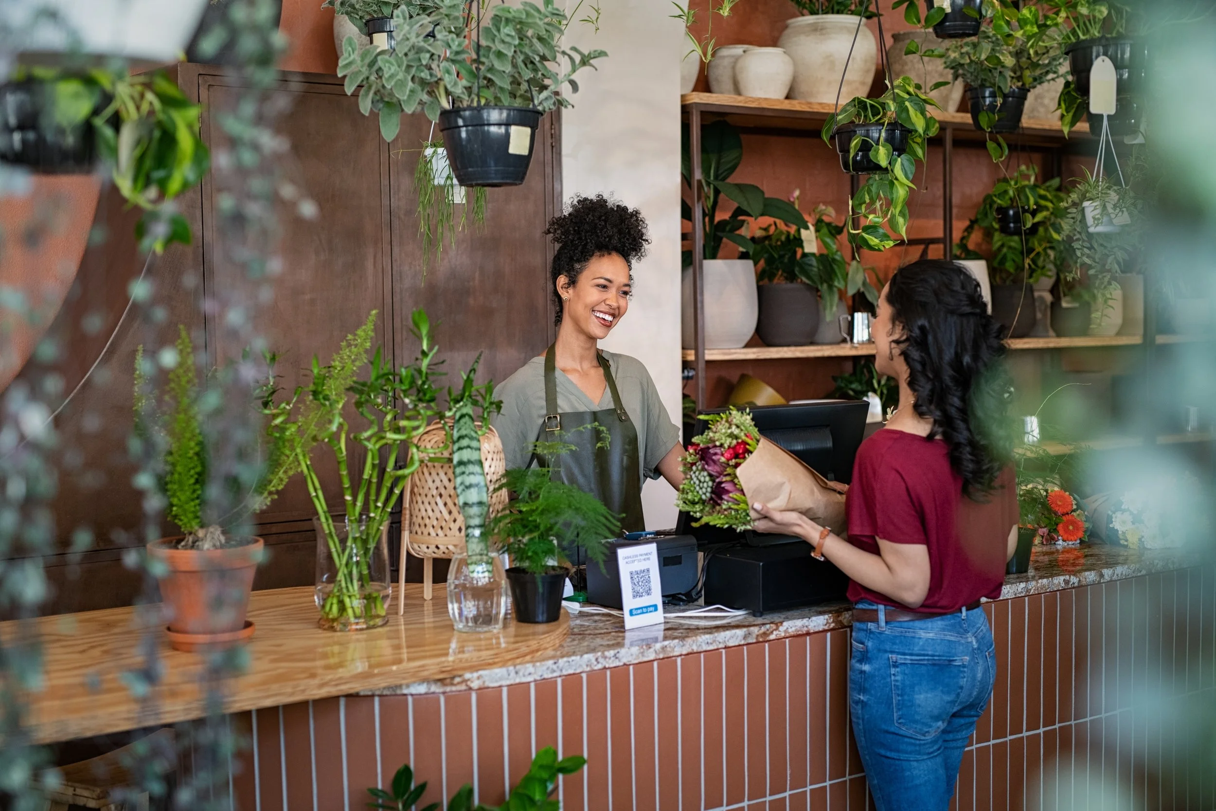 Woman purchasing flowers from a florist.