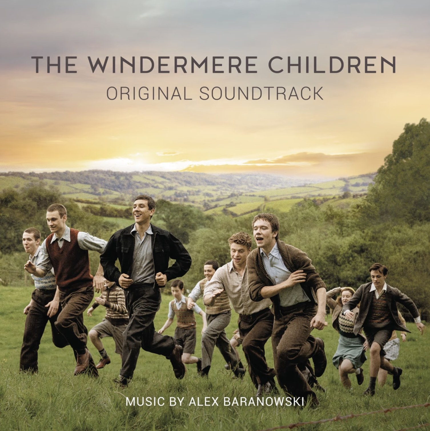 Cover art for The Windermere Children original soundtrack showing young boys running in a green field with rolling hills and a sunset sky in the background.