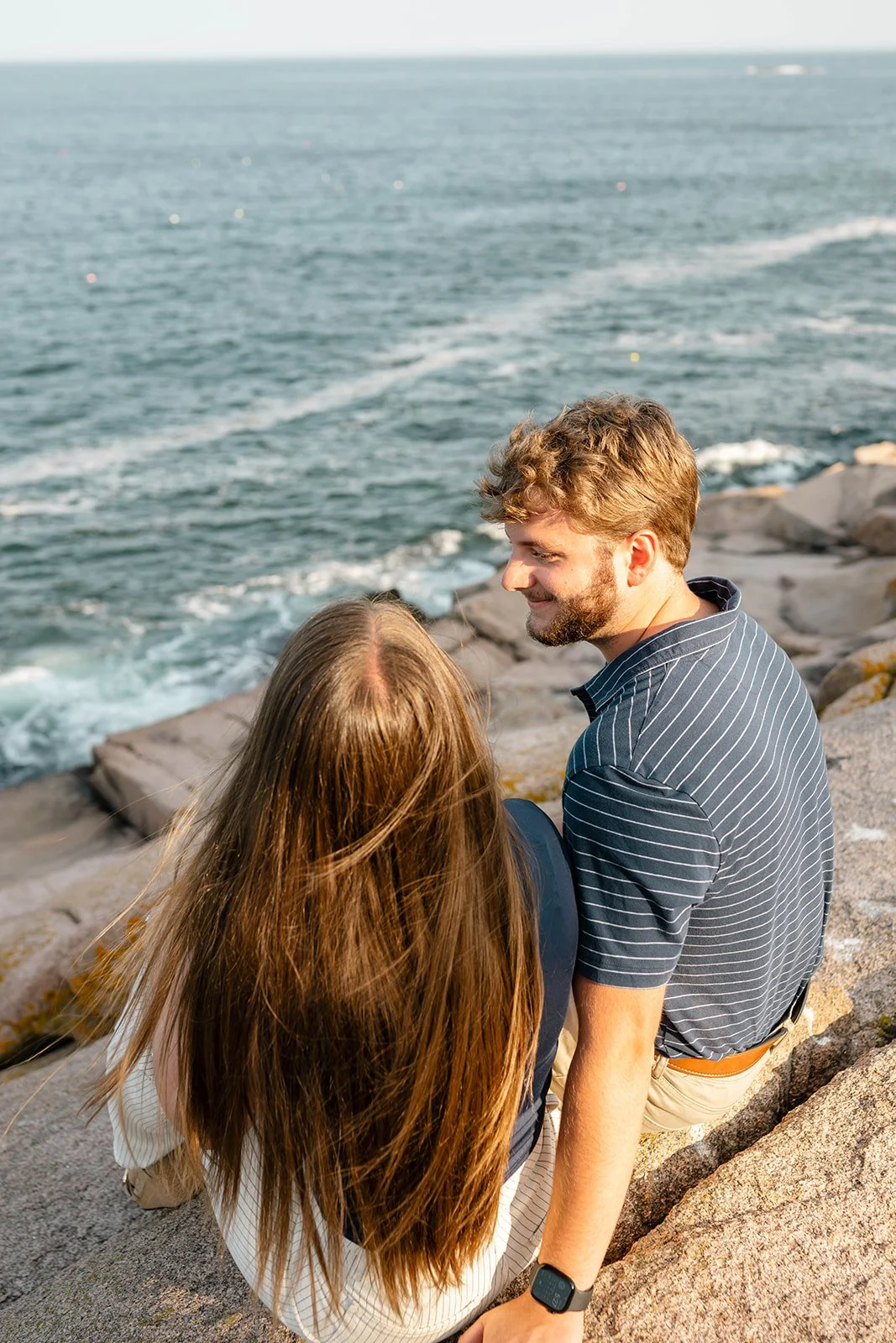 newly engaged couple enjoying the moment along the maine coast