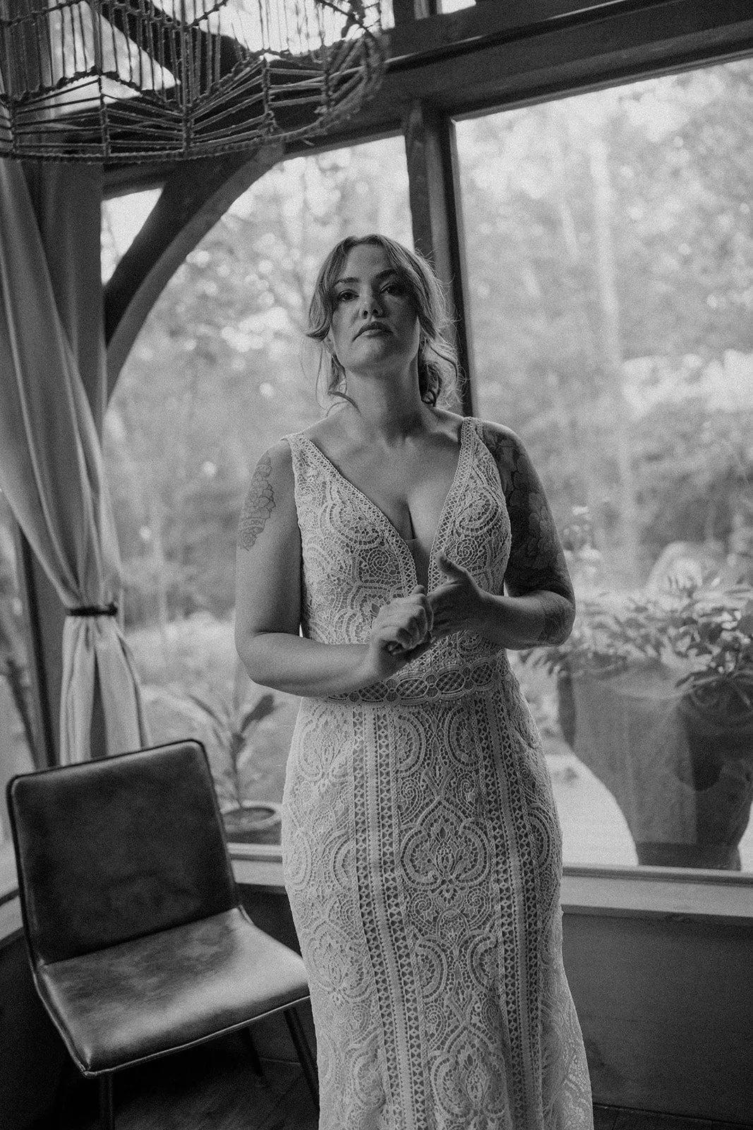 bride getting ready in front of a large lakeside cabin window