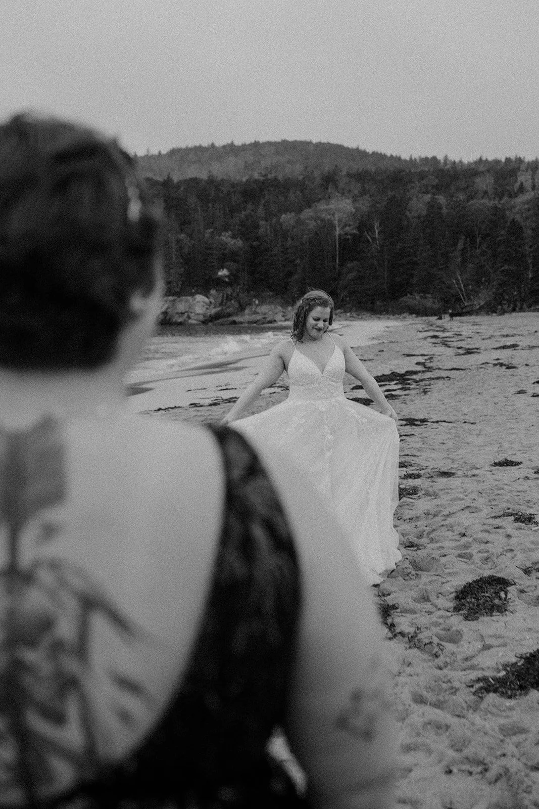 playful brides running around along sand beach shores in acadia