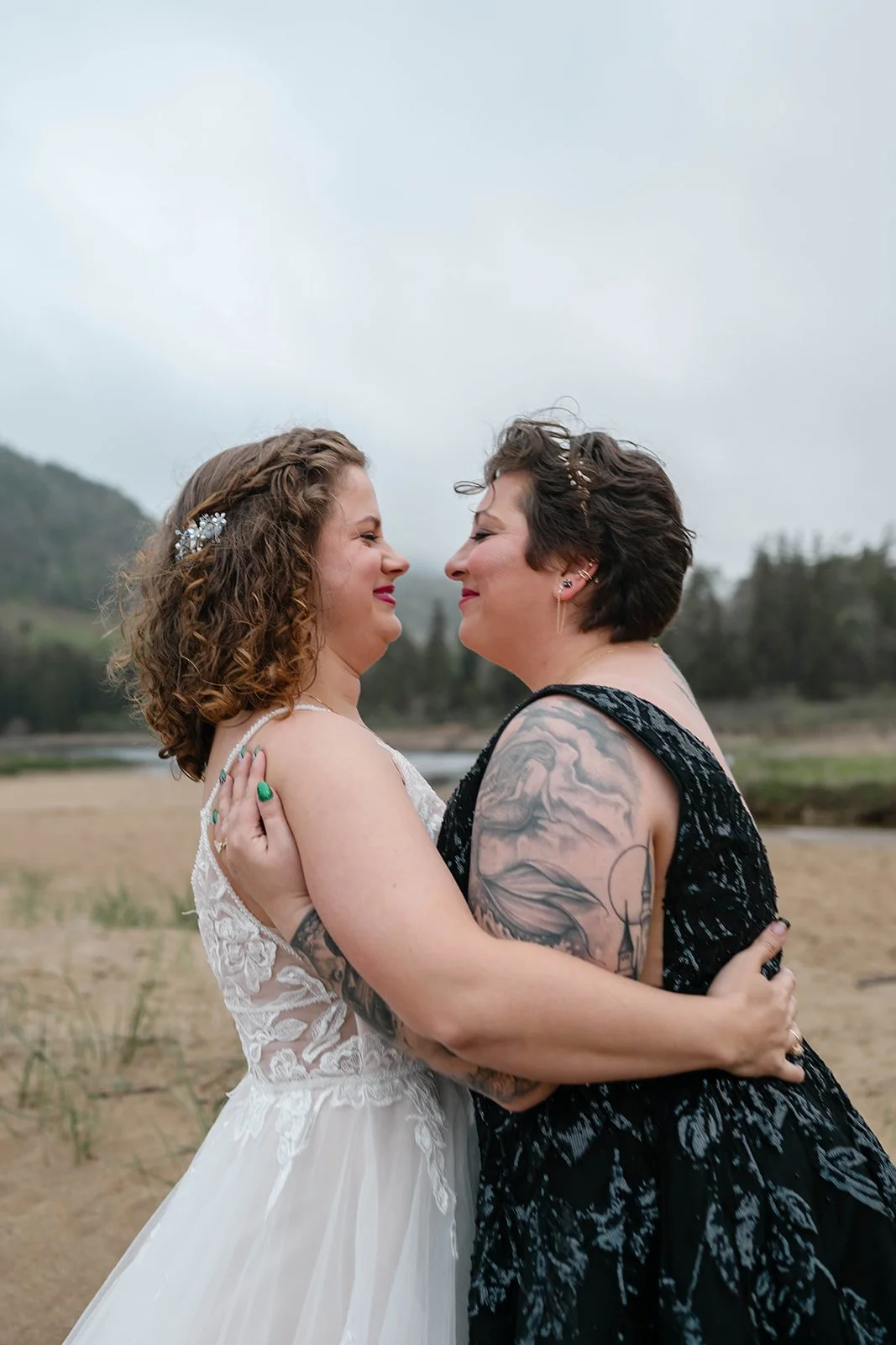 playful brides running around along sand beach shores in acadia