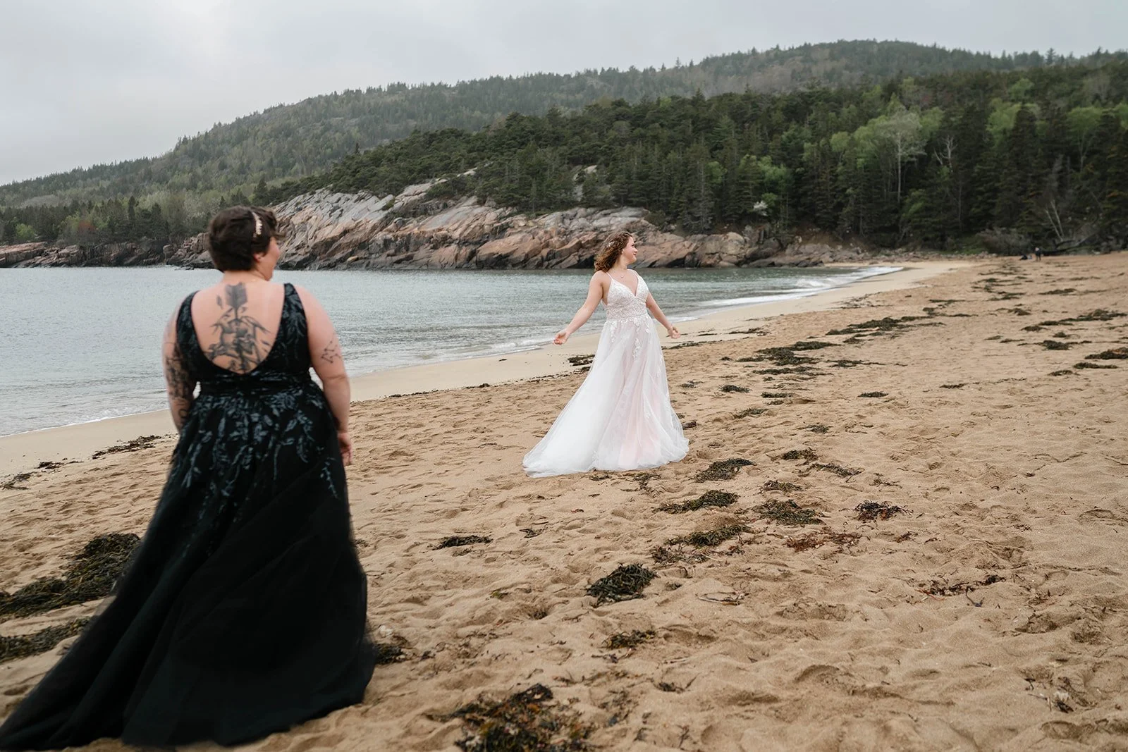 playful brides running around along sand beach shores in acadia