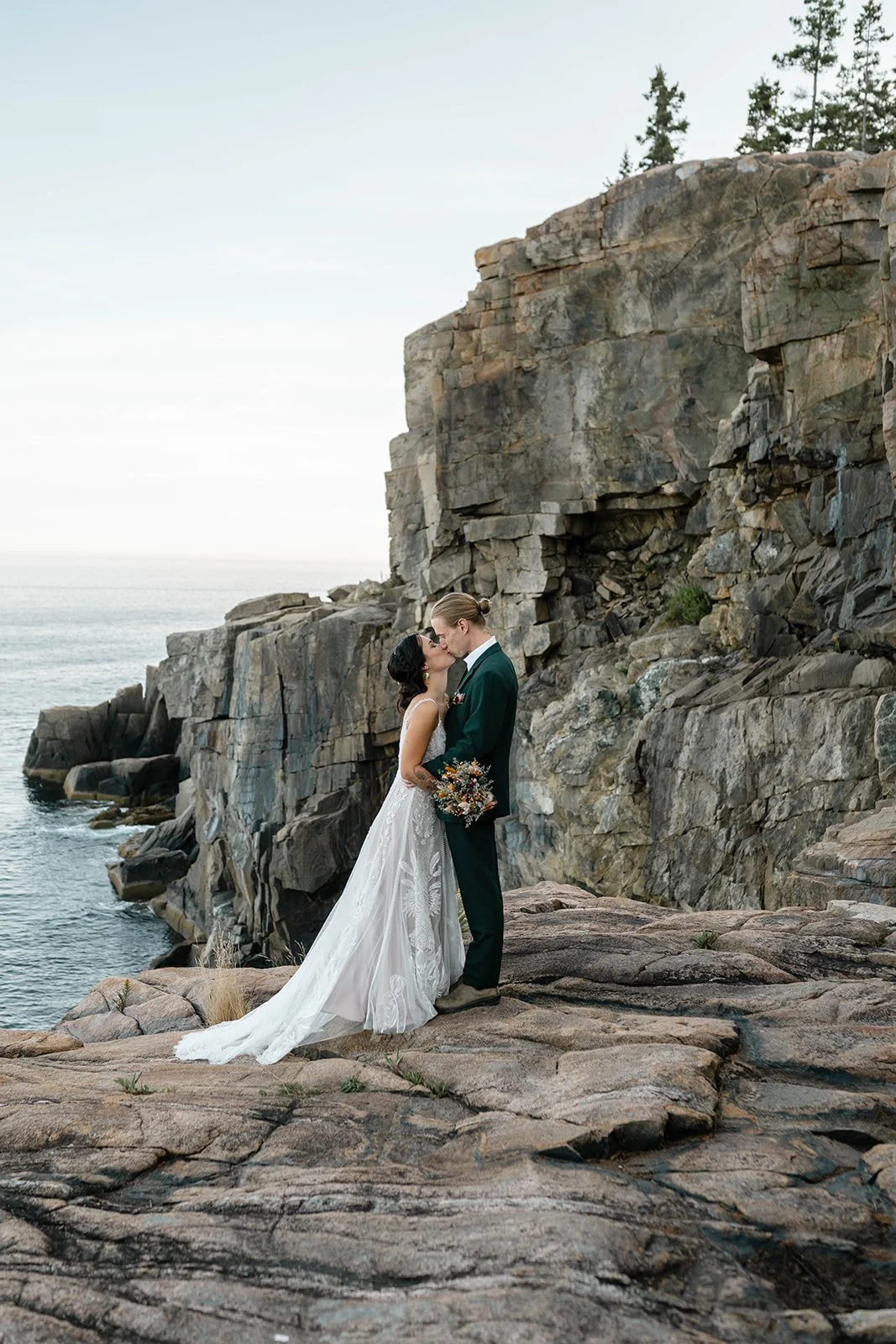 bride and groom hiking at otter cliff overlook in acadia national park