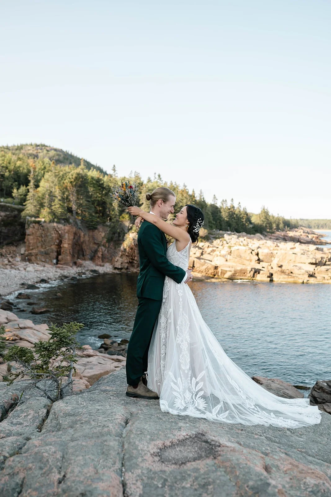 bride and groom hugging at monument cove during their acadia elopement