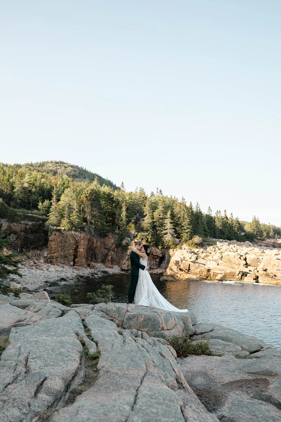 bride and groom hugging at monument cove during their acadia elopement
