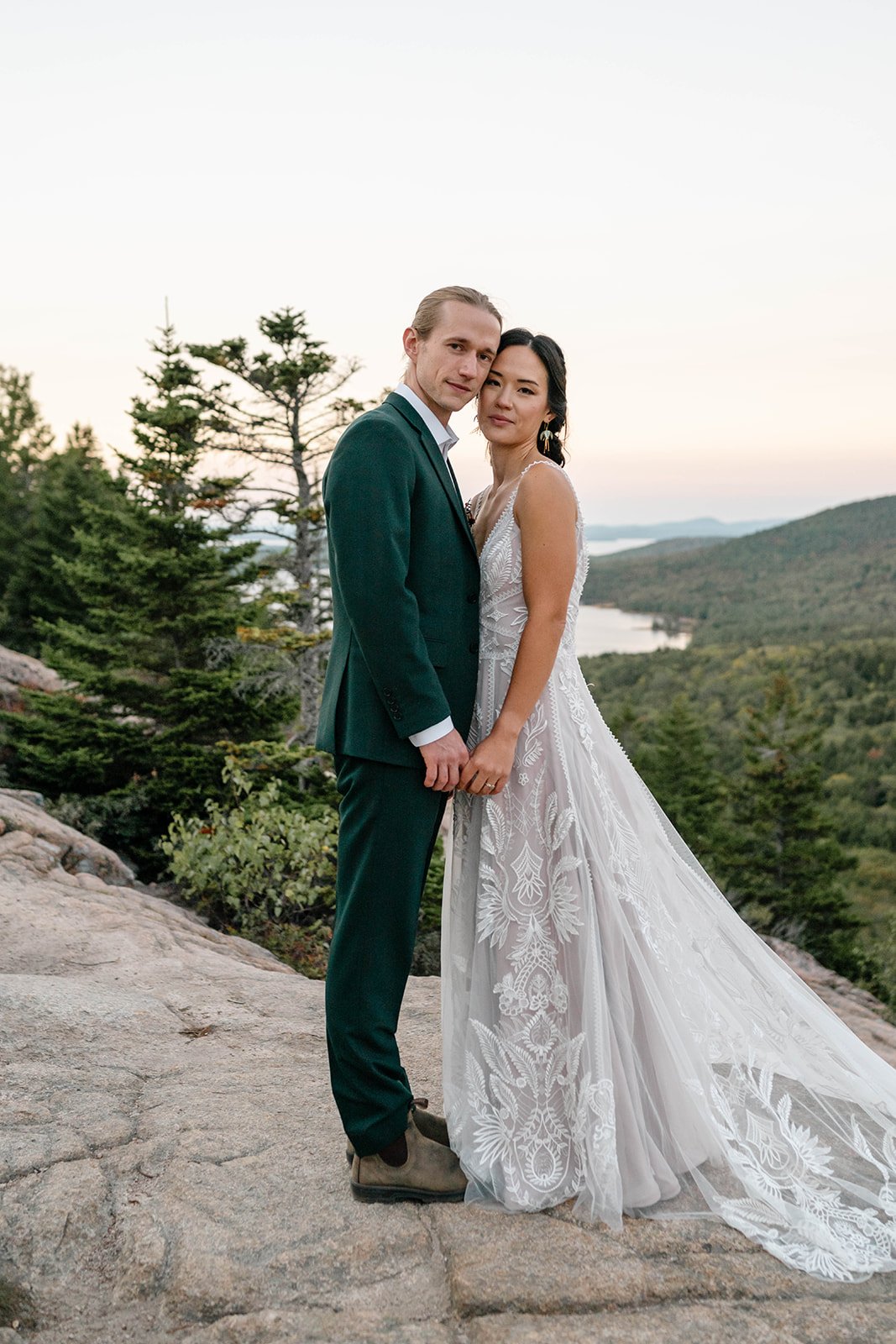 bride and groom holding hands on a cliff during their acadia elopement